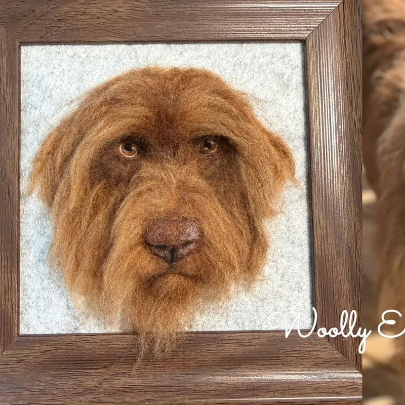 Framed needle felted brown dog portrait beside the live dog